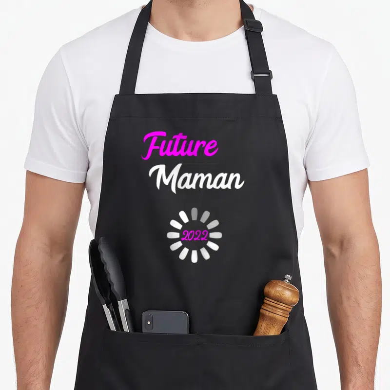 Tablier de cuisine noir avec texte Future Maman 2022 et icône de chargement rose et blanc.