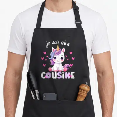 Tablier de cuisine noir avec une licorne rose et l'annonce Je vais être cousine