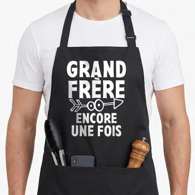 Tablier de cuisine noir avec texte blanc Grand Frère Encore Une Fois et dessin de flèche.