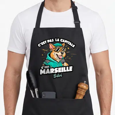 Tablier de cuisine noir avec illustration d'un chien en tenue de rappeur et texte C'est Marseille Bébé.