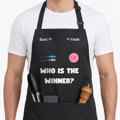 Tablier de cuisine noir avecWho is the winneret deux spermatozoïdes course vers une cellule ovule rose.