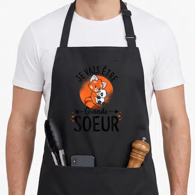 Tablier de cuisine noir avec illustration d'un panda roux tenant un petit panda et le texte Je vais être Grande Soeur.
