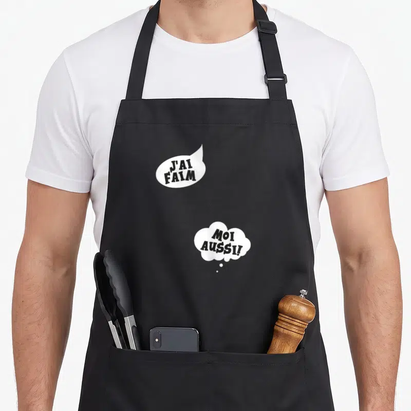 Tablier de cuisine noir avec deux bulles blanches contenant les textes J'ai faim et Moi aussi. en typographie noire.