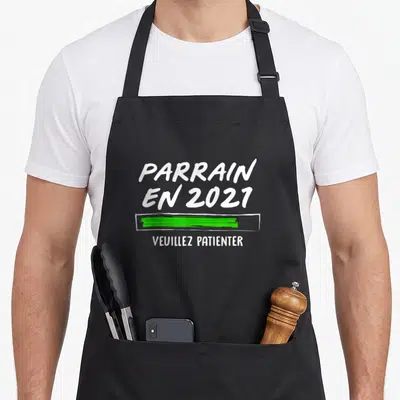 Tablier de cuisine noir avec l'inscription Parrain en 2021 et une barre de chargement verte.