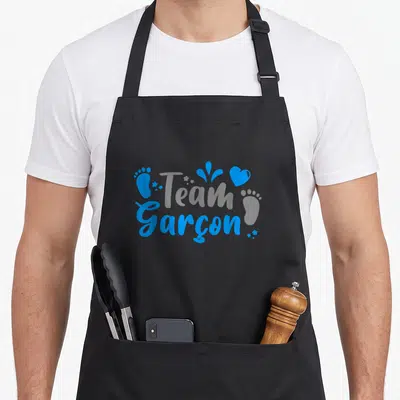 Tablier de cuisine noir avec inscription Team Garçon en bleu, empreinte de pied et cœur stylisé.