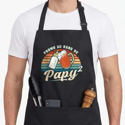Tablier de cuisine noir avec motif Promu au rang de Papy 2 illustré par un biberon et une bière.