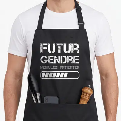 Tablier de cuisine noir avec inscription Futur Gendre Veuillez Patienter et barre de progression blanche en bas du motif central.
