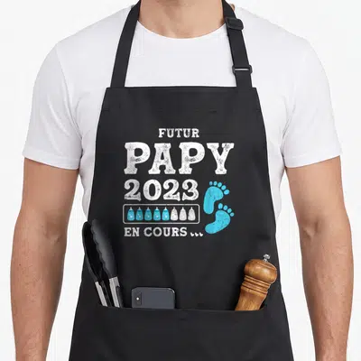 Tablier de cuisine noir avec inscription Futur Papy 2023 En Cours et petits pieds bleus.