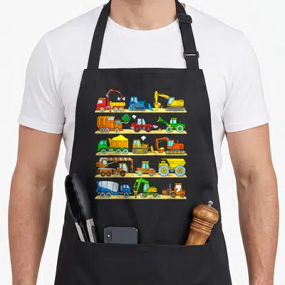 Tablier de cuisine noir avec cinq rangées d'engins de chantier colorés incluant camions, pelles et chargeuses sur fond beige.