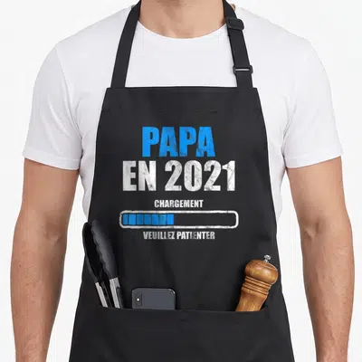 Tablier de cuisine noir avec inscription Papa en 2021 chargement et barre de progression bleue.