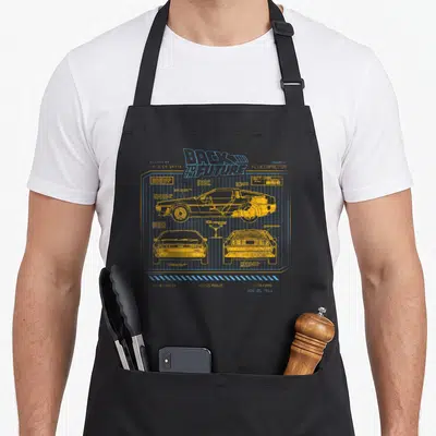Tablier de cuisine noir avec les schémas techniques jaunes et bleus de la DeLorean du film Back to the Future sur fond quadrillé.