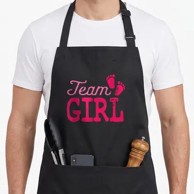 Tablier de cuisine noir avec inscription Team Girl en rose et deux empreintes de petits pieds de bébé.