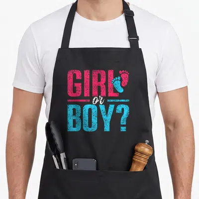 Tablier de cuisine noir avec inscription GIRL or BOY et deux petites empreintes de pieds colorées en rose et bleu vif.