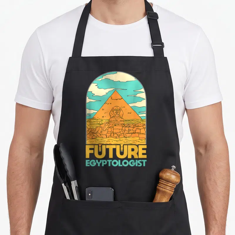 Tablier de cuisine noir avec une illustration colorée d'une pyramide, du Sphinx et le texte Future Egyptologist.