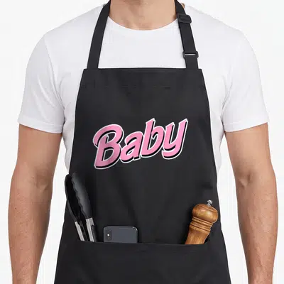 Tablier de cuisine noir avec l'inscription Baby en lettres roses et contours noirs