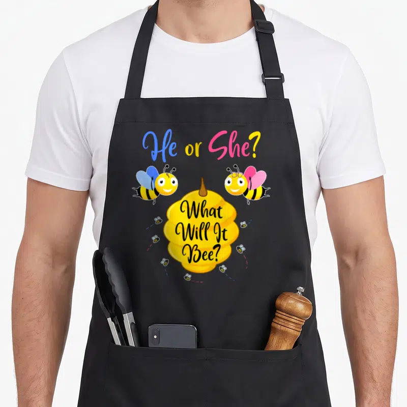 Tablier de cuisine noir avec deux abeilles colorées et une ruche jaune imprimée au centre.