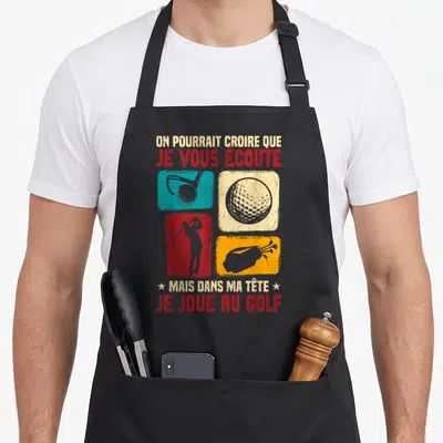 Tablier de cuisine noir avec quatre carrés colorés illustrant le golf et un texte humoristique en rouge et beige.