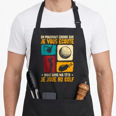 Tablier de cuisine noir avec inscription humoristique sur le golf et quatre illustrations colorées représentant des clubs, une balle et un golfeur.
