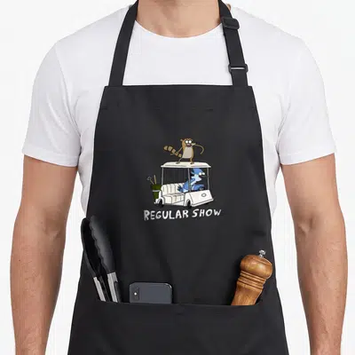 Tablier de cuisine noir avec illustration de Mordecai et Rigby dans une voiture de golf blanche et le texte Regular Show en dessous.