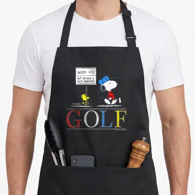 Tablier de cuisine noir avec Snoopy en golfeur, Woodstock et une pancarte de score humoristique.