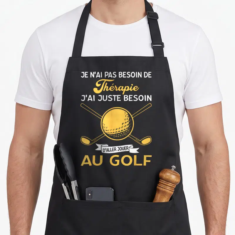 Tablier de cuisine noir avec inscription jaune et blanche sur le golf et deux clubs croisés.