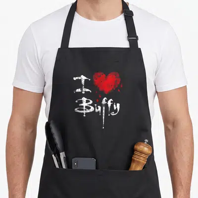 Tablier de cuisine noir avec inscription blanche J Buffy et un cœur rouge craquelé avec gouttes de sang.