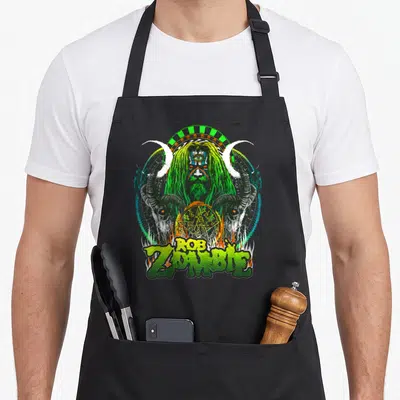 Tablier de cuisine noir avec illustration gothique vert et noir représentant un être triplement œillé encadré par des cornes de boucs.