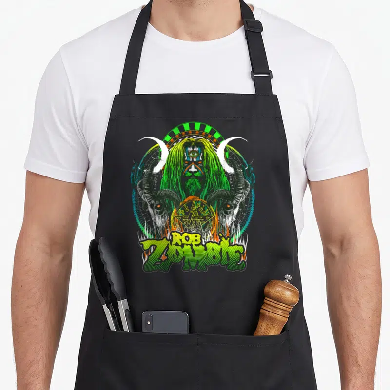 Tablier de cuisine noir avec illustration gothique vert et noir représentant un être triplement œillé encadré par des cornes de boucs.