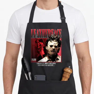 Tablier de cuisine noir avec illustration du tueur Leatherface et texte America's most bizarre and brutal killer