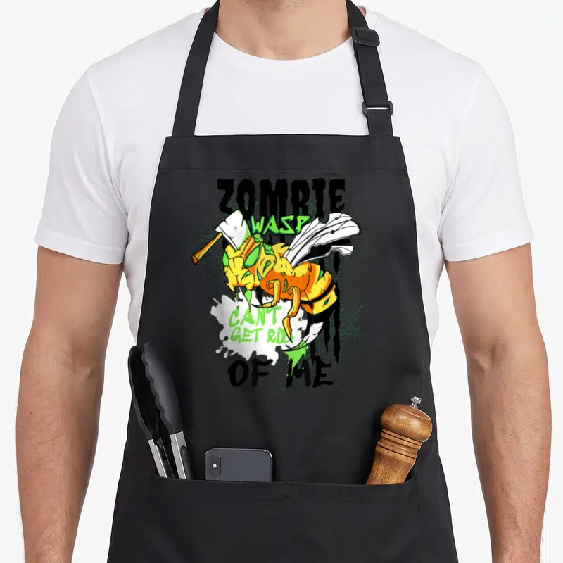 Tablier de cuisine noir avec illustration colorée d'une guêpe zombie tenant un couteau de boucher et du texte en anglais.
