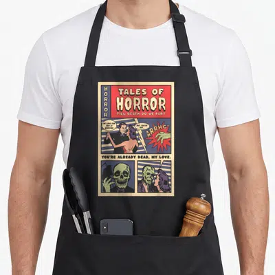 Tablier de cuisine noir avec une illustration style comics d'horreur vintage montrant un couple et des squelettes sous le titre Tales of Horror.