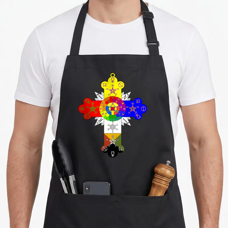 Tablier de cuisine noir avec une grande croix colorée comportant des symboles alchimiques et des pentagrammes sur fond uni.