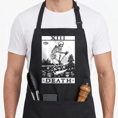 Tablier de cuisine noir avec illustration blanche carte tarot Death XIII squelette et faucille style gravure ancienne.