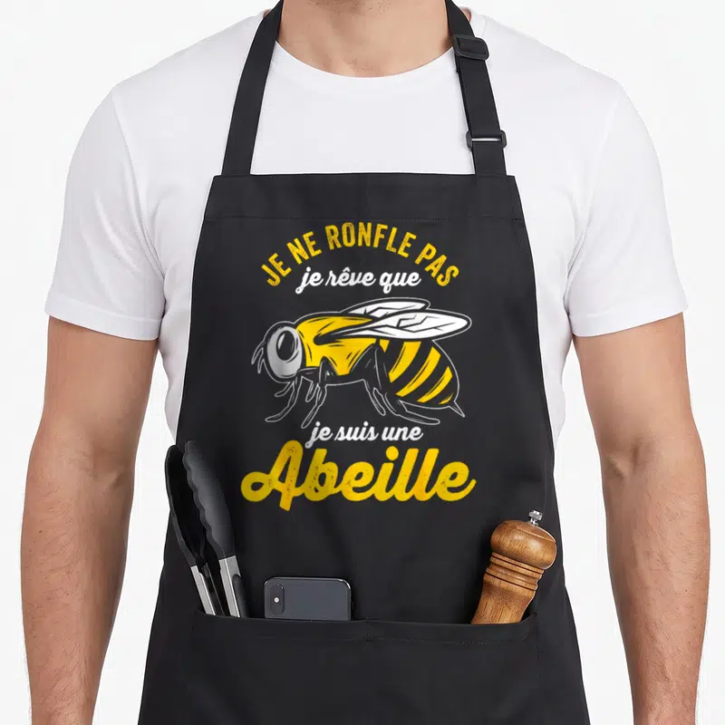 Tablier de cuisine noir avec une illustration d'abeille jaune et le texte Je ne ronfle pas je rêve que je suis une Abeille.