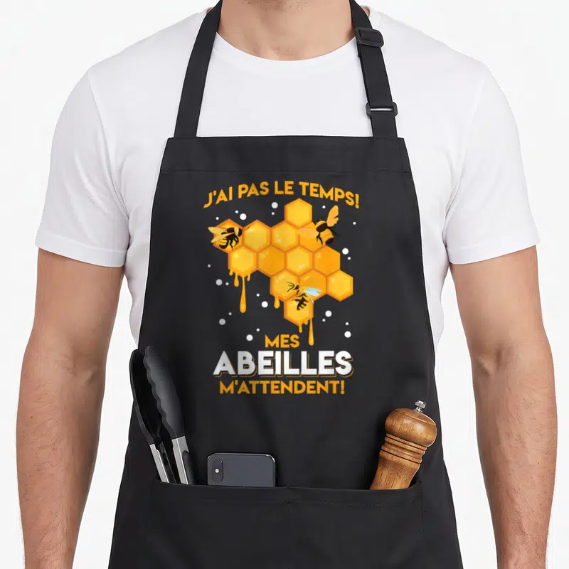 Tablier de cuisine noir avec une ruche dorée, des abeilles volantes et le texte J'ai pas le temps mes abeilles m'attendent.