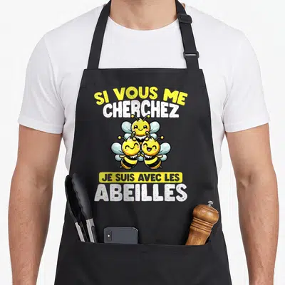 Tablier de cuisine noir avec trois abeilles jaunes souriantes et le texte Si Vous Me Cherchez Je Suis Avec Les Abeilles.