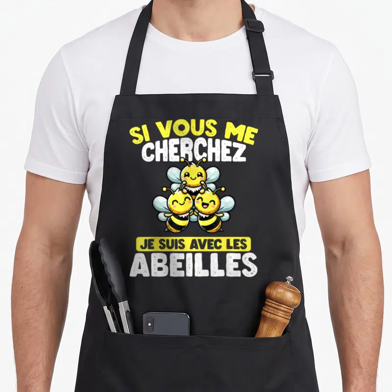 Tablier de cuisine noir avec trois abeilles jaunes souriantes et le texte Si Vous Me Cherchez Je Suis Avec Les Abeilles.
