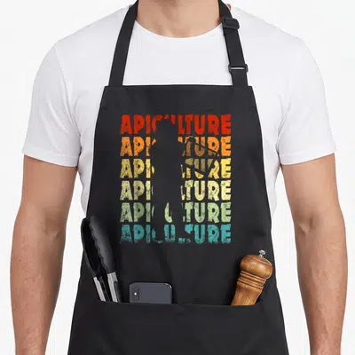 Tablier de cuisine noir avec motif Apiculture en lettres colorées et silhouette d'abeille centrale style vintage