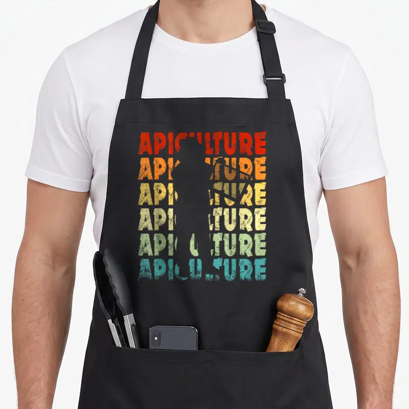 Tablier de cuisine noir avec motif Apiculture en lettres colorées et silhouette d'abeille centrale style vintage