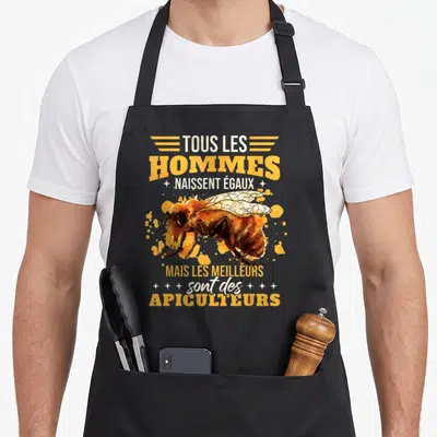 Tablier de cuisine noir avec inscription tous les hommes naissent égaux mais les meilleurs sont des apiculteurs et une illustration d'abeille orange.