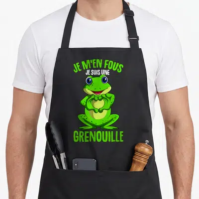 Tablier de cuisine noir avec une grenouille verte souriante formant un cœur avec ses mains et du texte imprimé.