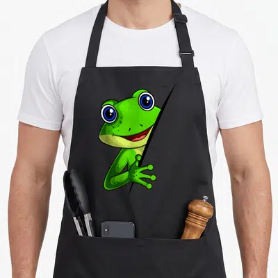 Tablier de cuisine noir avec une grenouille verte aux grands yeux bleus souriante qui peek behind a black fold.