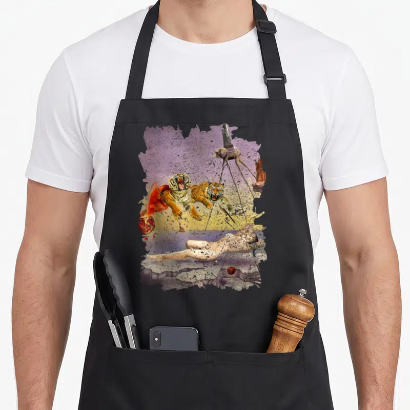 Tablier de cuisine noir avec une reproduction du rêve de Dali montrant des tigres et un éléphant aux longues pattes.