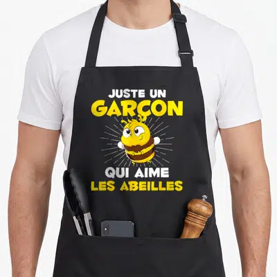 Tablier de cuisine noir avec une illustration de guêpe jaune et le texte Juste un garçon qui aime les abeilles en lettres blanches et jaunes.