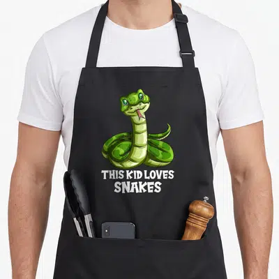 Tablier de cuisine noir avec un serpent vert dessiné et le texte This Kid Loves Snakes en blanc.