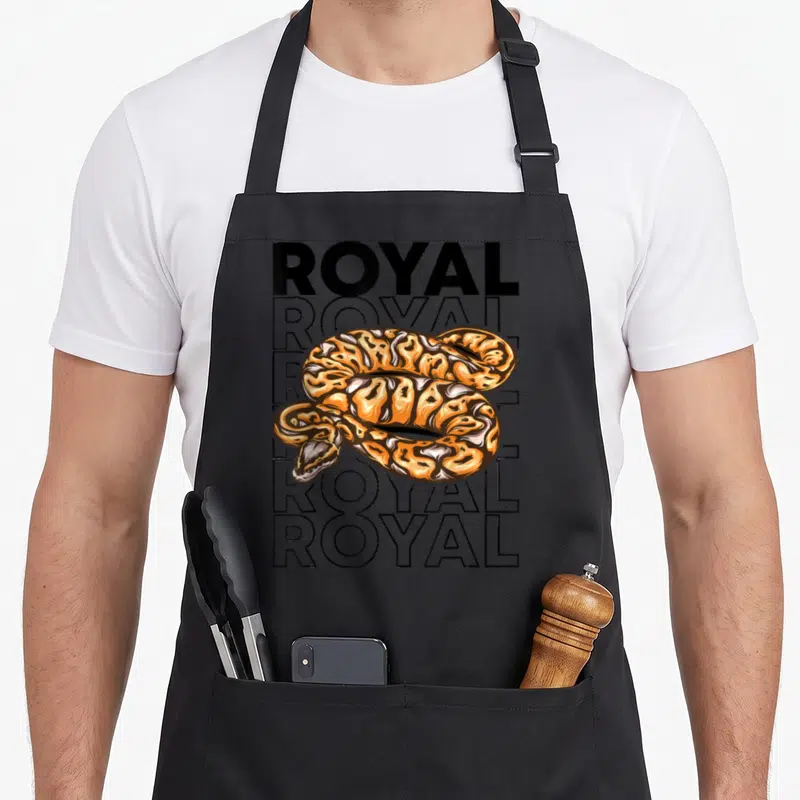 Tablier de cuisine noir avec illustration d'un python royal orange et texte royal en arrière-plan.