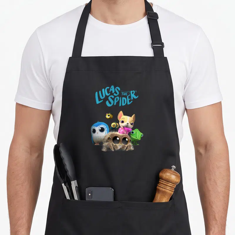 Tablier de cuisine noir avec Lucas l'araignée, un chien, une chouette bleue et d'autres petits animaux colorés imprimés au centre.