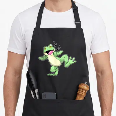 Tablier de cuisine noir avec illustration d'une grenouille verte dansante aux notes de musique noires flottant près de sa bouche ouverte.
