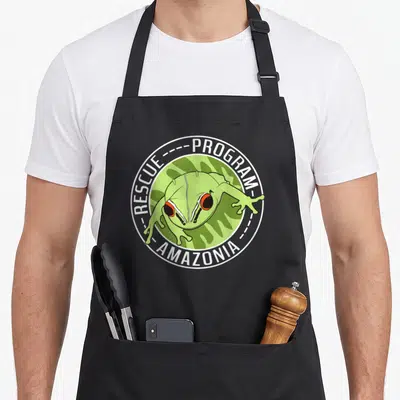 Tablier de cuisine noir avec logo circulaire Rescue Program Amazonia et grenouille verte aux yeux rouges.