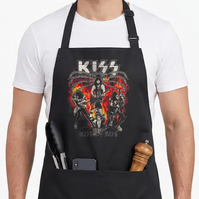 Tablier de cuisine noir avec illustration de groupe de rock KISS et flammes rouges.